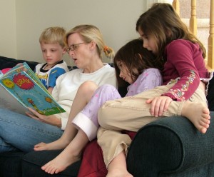 Madre leyendo libro a sus hijos